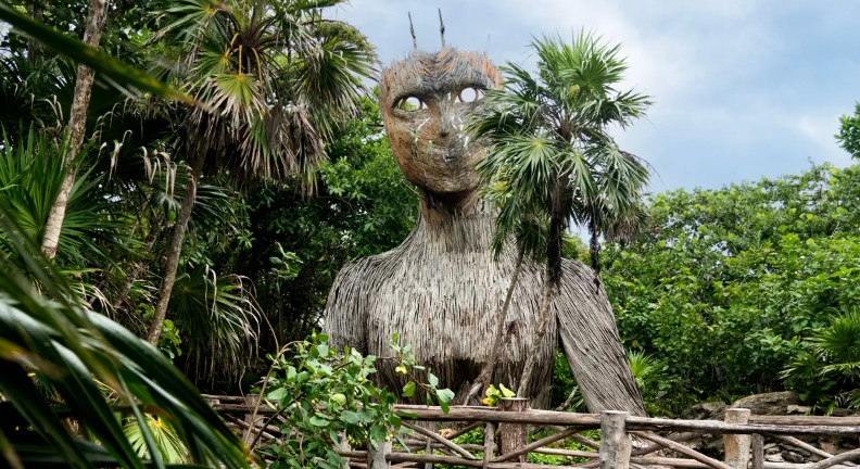 Straw man sculpture in garden at Palmaia resort Riviera Maya Mexico