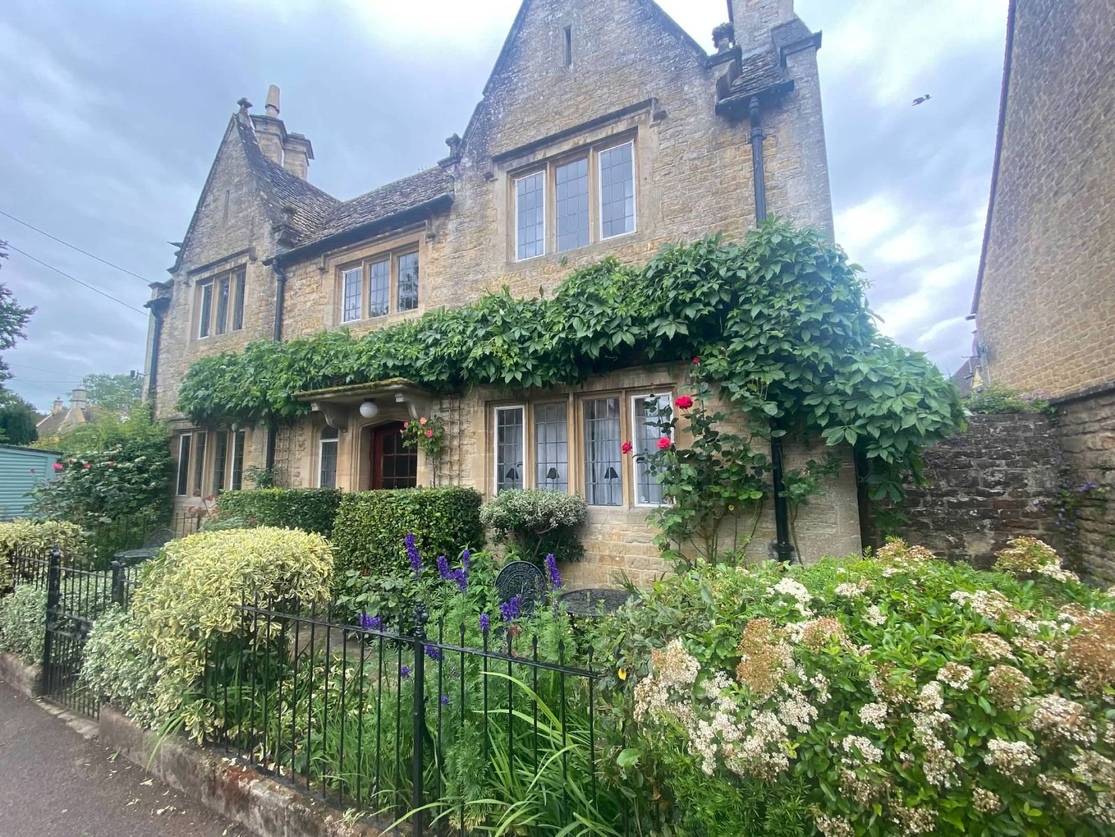 Golden stone village street in the Cotswolds on an overcast afternoon