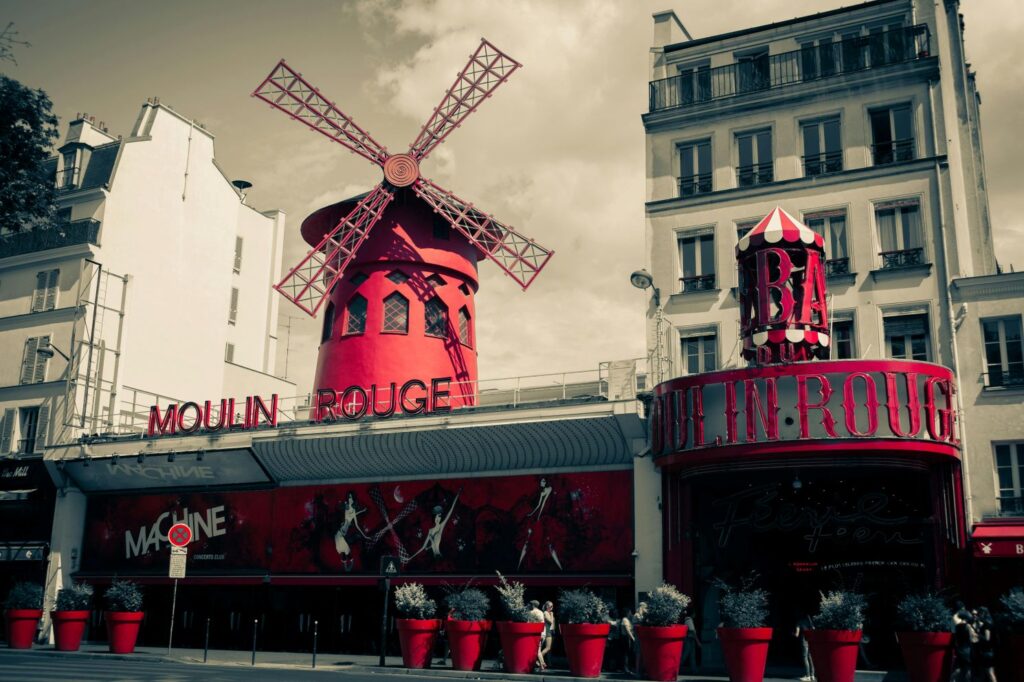 Exterior of the iconic Moulin Rouge cabaret in Paris, with its famous red windmill and illuminated façade.